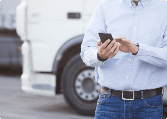 a man checks a message on this phone with a truck in the background