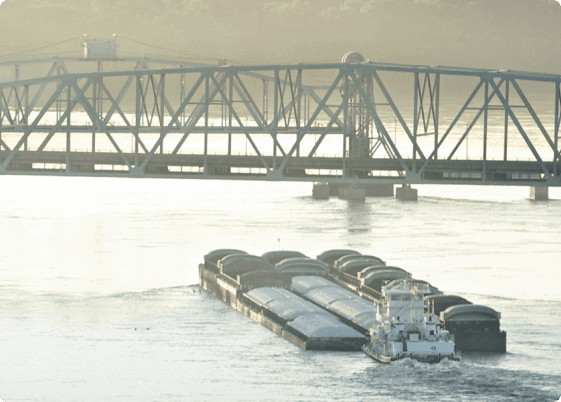 a river barge goes under a bridge